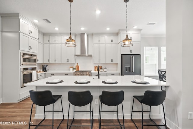 152 Navigators Rd, Saint Johns, FL 32259 - kitchen featuring a kitchen breakfast bar, stainless steel appliances, light countertops, visible vents, and wall chimney exhaust hood