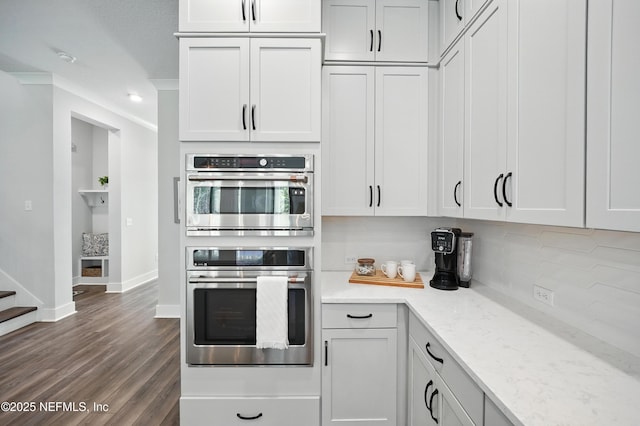152 Navigators Rd, Saint Johns, FL 32259 - kitchen with white cabinets, double oven, backsplash, baseboards, and dark wood-style flooring