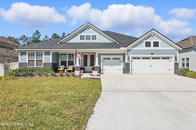 craftsman-style house featuring driveway, a garage, stone siding, french doors, and a front lawn