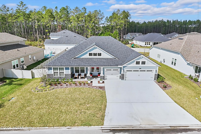 view of front of home with an attached garage, driveway, fence, and a front yard