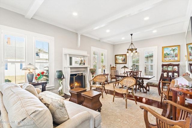 living area featuring recessed lighting, beam ceiling, a lit fireplace, and wood finished floors