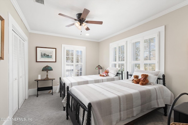 bedroom featuring light carpet, baseboards, ornamental molding, and a closet