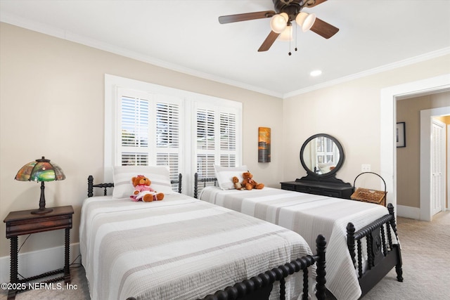 bedroom with carpet floors, crown molding, baseboards, and a ceiling fan