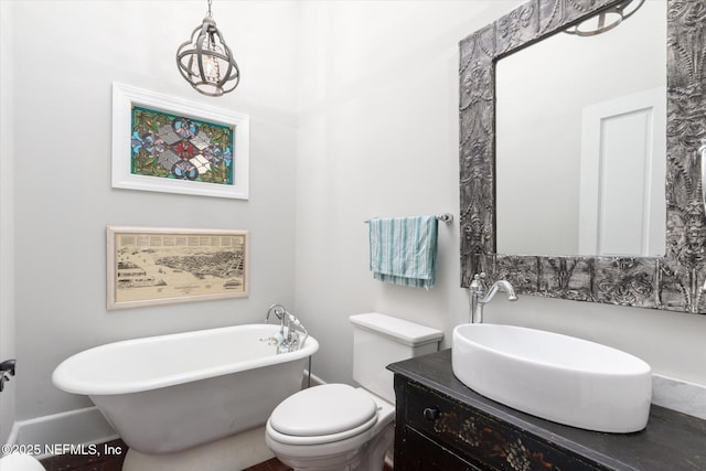 bathroom with toilet, a freestanding bath, and vanity