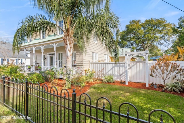 exterior space with covered porch and a fenced front yard