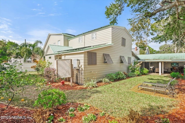 rear view of property featuring a garden, fence, and a lawn