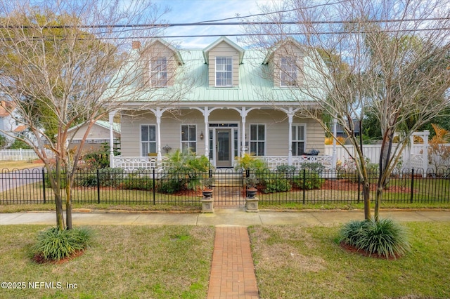 view of front facade with a fenced front yard, covered porch, a front yard, a gate, and metal roof