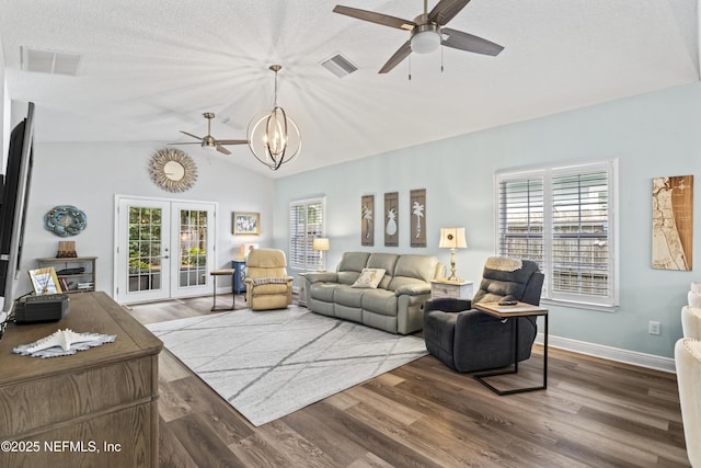 living room with lofted ceiling, french doors, visible vents, and wood finished floors