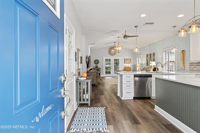 kitchen with open floor plan, light countertops, decorative light fixtures, and stainless steel dishwasher