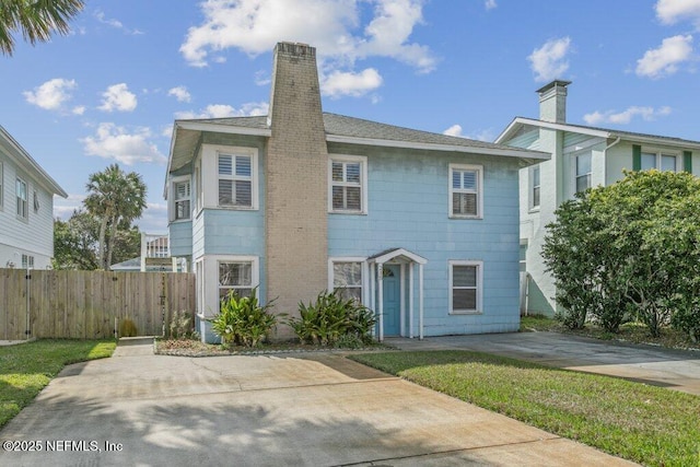 view of front of home with a chimney and fence