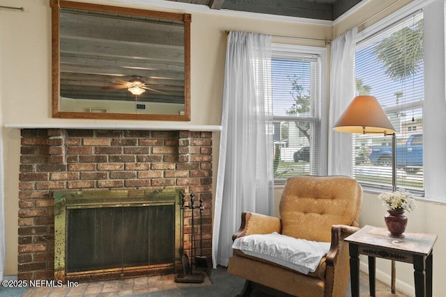 living area with a brick fireplace, ceiling fan, and a wealth of natural light