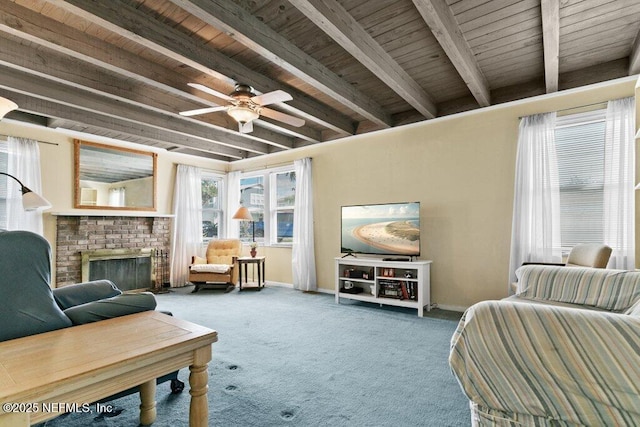 sitting room with carpet floors, beam ceiling, a fireplace, and baseboards