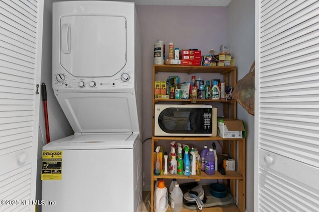 clothes washing area featuring laundry area and stacked washing maching and dryer