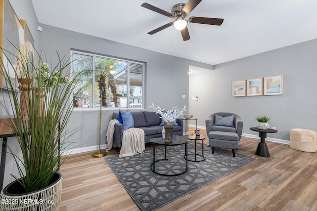 living room featuring ceiling fan, wood finished floors, and baseboards