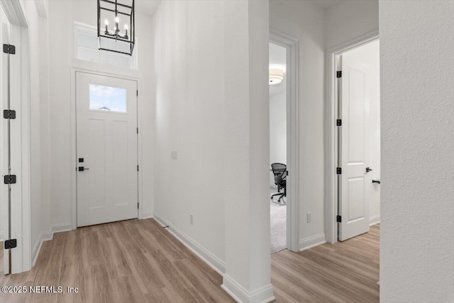 foyer with baseboards and wood finished floors