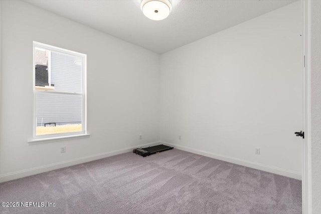 carpeted empty room with baseboards