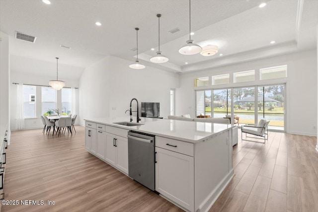 kitchen with visible vents, dishwasher, light wood-style flooring, and a sink