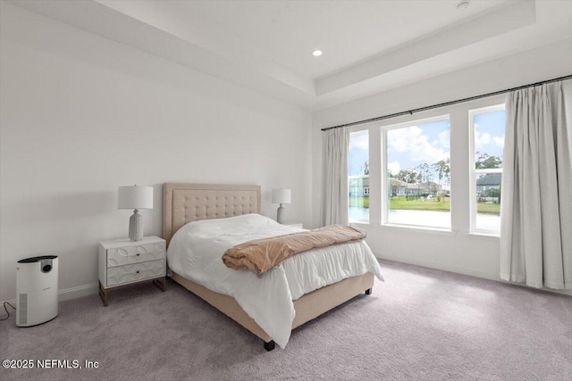 bedroom with a tray ceiling, carpet flooring, baseboards, and recessed lighting