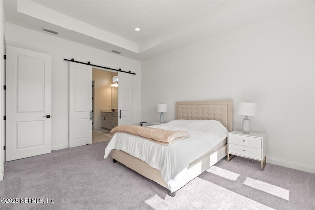 bedroom featuring carpet flooring, visible vents, baseboards, and a barn door