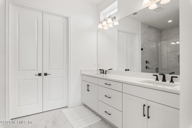 bathroom featuring marble finish floor, double vanity, a sink, and a marble finish shower