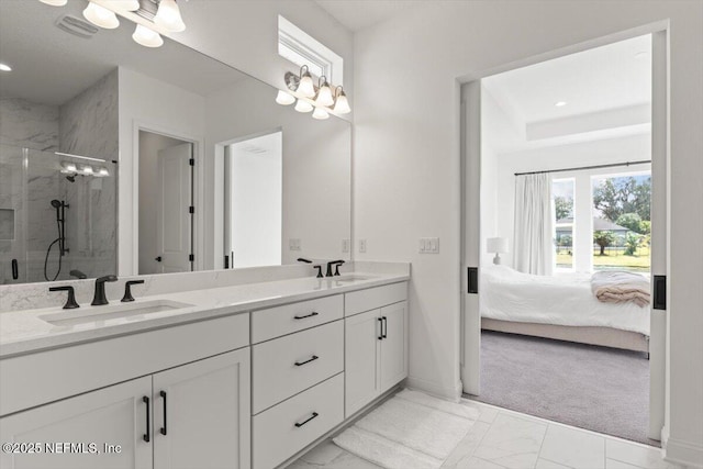 bathroom with marble finish floor, a shower stall, a sink, and ensuite bathroom