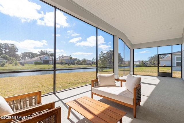 sunroom featuring a water view