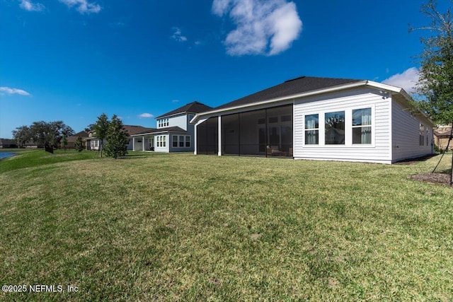 back of property with a sunroom and a lawn