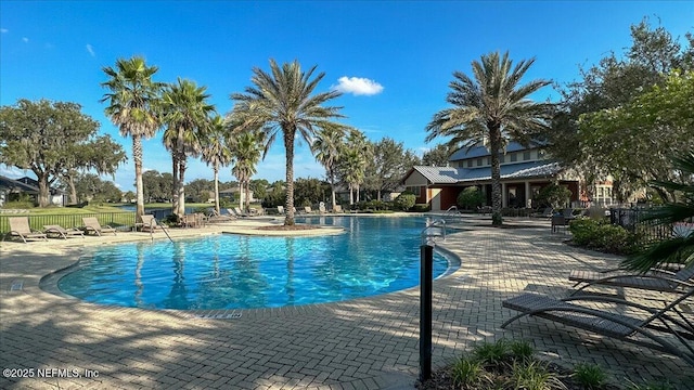 community pool featuring fence and a patio