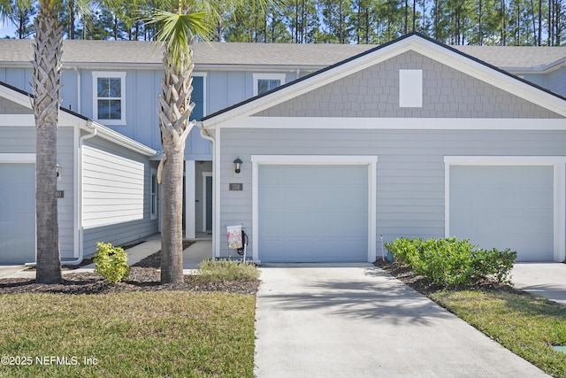 view of front facade featuring driveway, board and batten siding, and an attached garage