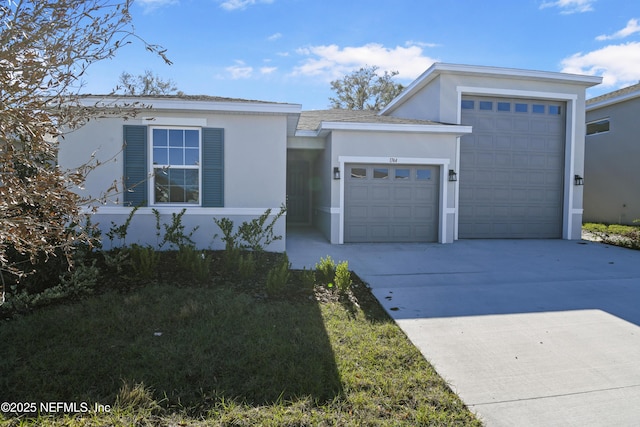 view of front of home featuring a garage, concrete driveway, and stucco siding