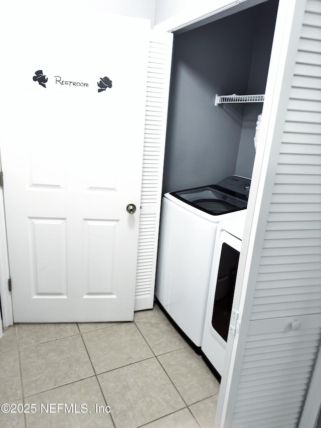 washroom with laundry area, washer and clothes dryer, and light tile patterned floors