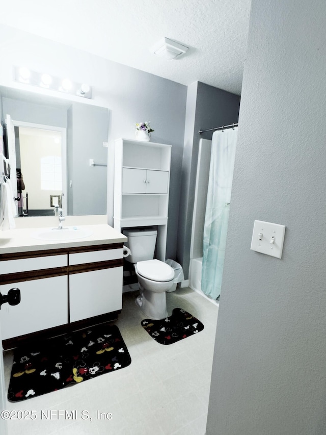 full bathroom featuring toilet, tile patterned floors, shower / bath combo with shower curtain, a textured ceiling, and vanity