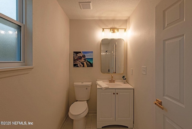 bathroom with visible vents, toilet, a textured ceiling, vanity, and baseboards