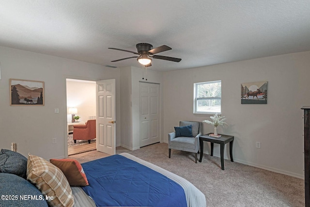 bedroom featuring light carpet, a textured ceiling, visible vents, and baseboards