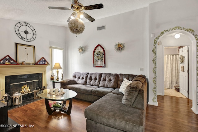 living room with visible vents, a high end fireplace, ceiling fan, a textured ceiling, and wood finished floors