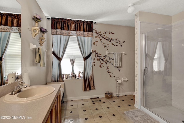 bathroom featuring a healthy amount of sunlight, a shower stall, a textured ceiling, and vanity