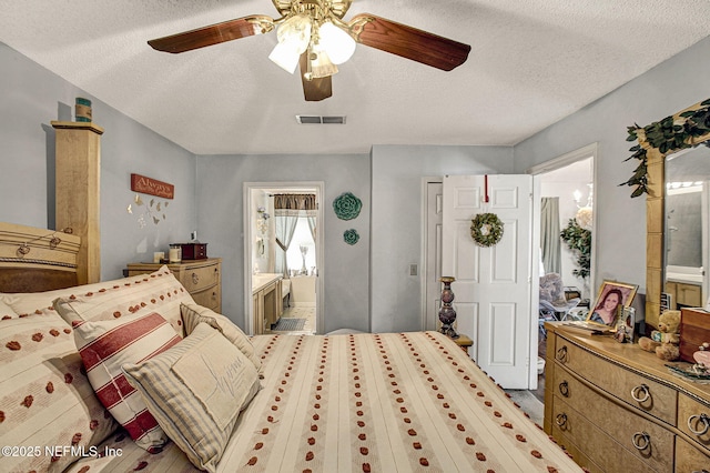 bedroom featuring ensuite bath, visible vents, ceiling fan, and a textured ceiling