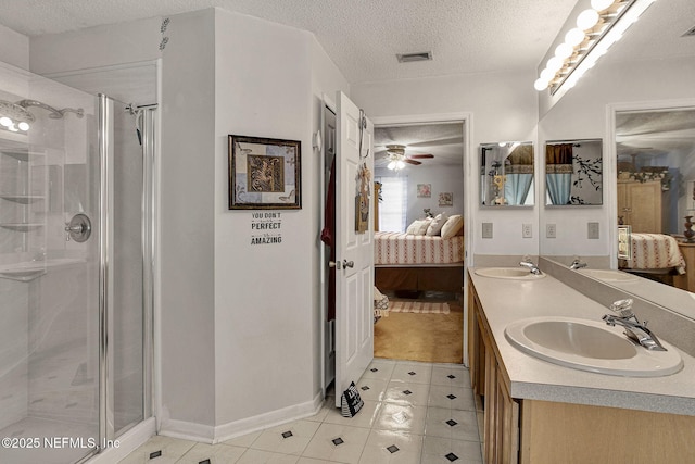 ensuite bathroom with a textured ceiling, connected bathroom, a sink, visible vents, and a stall shower