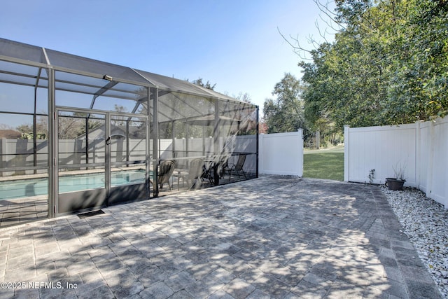 view of patio with glass enclosure, fence, and a fenced in pool