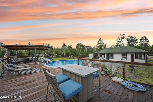 outdoor pool featuring a wooden deck and outdoor dining area