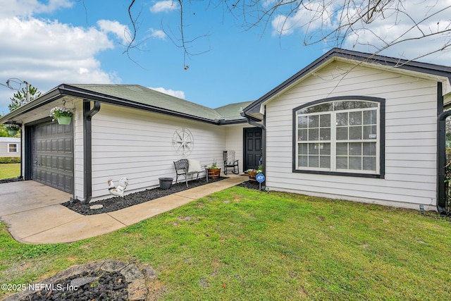 back of property with a lawn and an attached garage