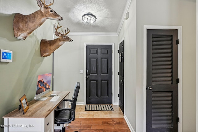 entrance foyer featuring crown molding, wood finished floors, baseboards, and a textured ceiling