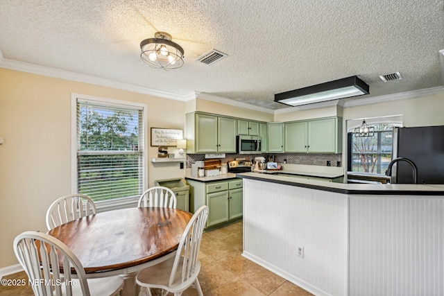 kitchen featuring green cabinets, crown molding, visible vents, and appliances with stainless steel finishes