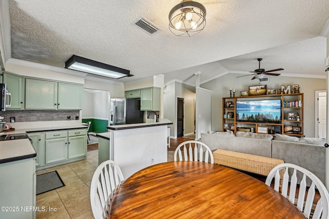 dining area with visible vents, crown molding, light tile patterned floors, lofted ceiling, and ceiling fan