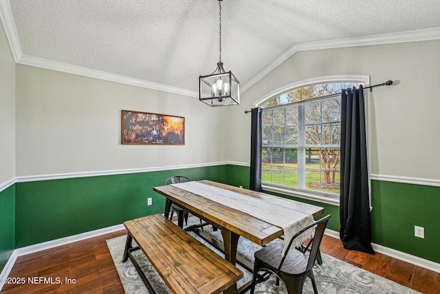 dining area with a notable chandelier, lofted ceiling, a textured ceiling, wood finished floors, and baseboards