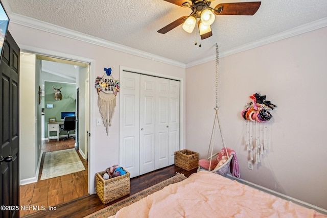 bedroom featuring a ceiling fan, wood finished floors, a closet, a textured ceiling, and crown molding