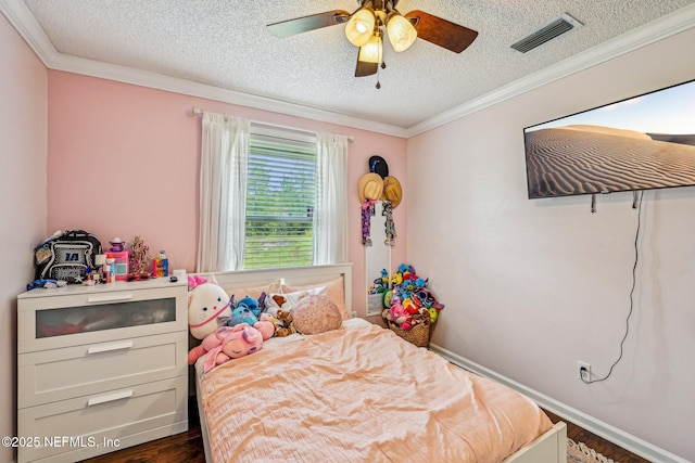 bedroom with a textured ceiling, visible vents, dark wood-style flooring, and ornamental molding