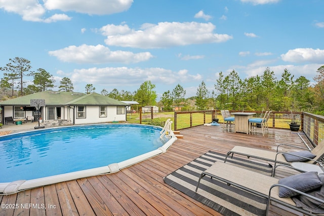 pool featuring outdoor dining space, a lawn, and a deck