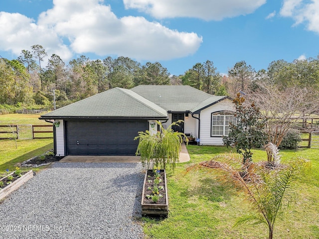 ranch-style home with a front yard, driveway, and fence