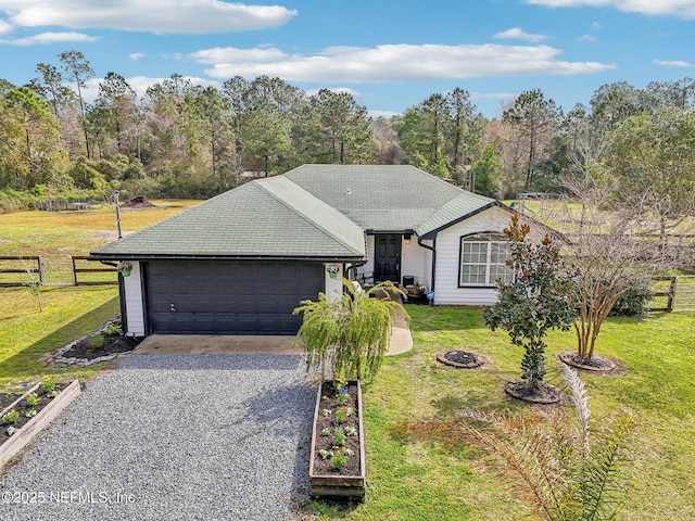 ranch-style home with gravel driveway, a front yard, and fence